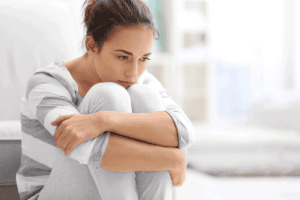 woman sits with her knees to her chest and asks herself do i have a personality disorder