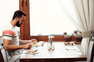 a man sits alone in a restaurant and wonders if he is experiencing compulsive eating