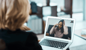 a person is on a telehealth appointment on their laptop while asking themselves how does telehealth work