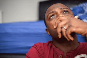 distraught man holds his hand to his mouth while looking ahead and thinking about generalized anxiety disorder