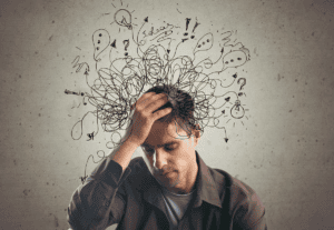 man holds hand to his head while struggling with the question of is adhd a disability