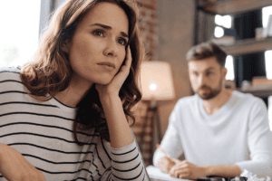 woman rests her palm on the side of her face while her boyfriend talks to her about the connection between adhd and relationships
