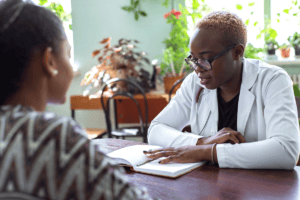 a mental health professional sits with a patient and discusses what is transcranial magnetic stimulation and how it can help
