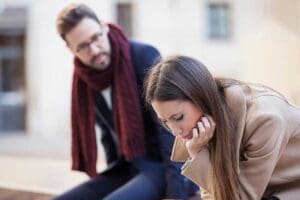 a man and woman sit together discussing how anger and relationships can impact each other