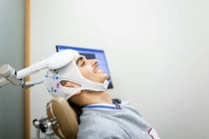 a patient sits in a chair and is going through tms therapy for ocd
